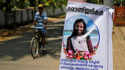 A man pedals his bicycle past a poster of Anzi Ali Bhava in Kodungalloor town in the southern state of Kerala, India. Reuters
