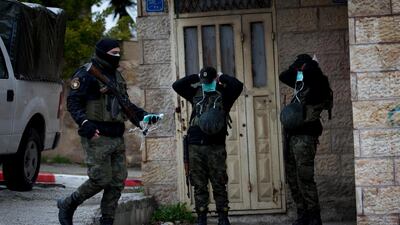 Members of Palestinian security forces wear masks as a preventive measure against the coronavirus as they stand guard outside a hotel in which staff tested positive in Bethlehem. AP