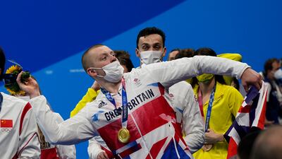 Adam Peaty, of Britain, celebrates at the podium after winning the gold medal in the mixed 4x100m medley.