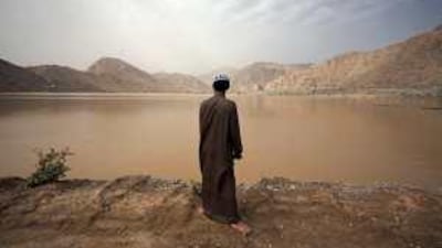 Hamed al Jesmy, 23, an Abu Dhabi police officer, gazes at the unfamiliar sight of water filling the Wadi Bih dam near Ras al Khaimah yesterday.