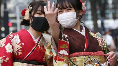 Kimono-clad women wearing face masks to protect against the spread of the coronavirus pose for a selfie together following a Coming-of-Age ceremony in Yokohama, near Tokyo. AP Photo