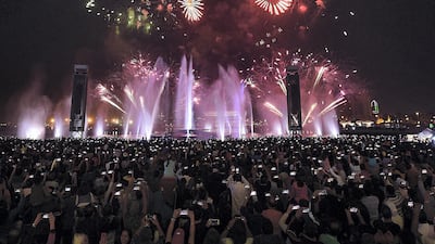 People enjoy the fireworks at Dubai Festival City in Dubai on Monday. Satish Kumar/ for The National