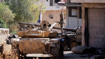 A Syrian army soldier holds a Syrian flag as he stands on a military vehicle in Khan Sheikhoun, Idlib, Syria. Reuters