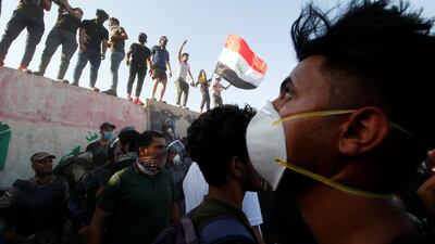 Iraqi protesters stand on concrete blast walls during a protest near the government office building in Basra. Reuters