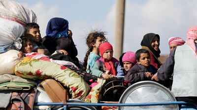 Internally displaced people ride on the back of a truck with their belongings in the town of Inab, eastern Afrin, Syria on March 12, 2018. Khalil Ashawi / Reuters