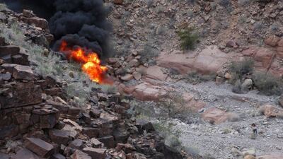A survivor, lower right, walks away from the scene of a deadly tour helicopter crash along the jagged rocks of the Grand Canyon in Arizona. AP.