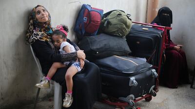 A Palestinian woman holds her daughter as they wait for a travel permit to cross into Egypt through the Rafah border crossing after it was opened by Egyptian authorities for humanitarian cases, in Rafah in the southern Gaza Strip August 16, 2017. Ibraheem Abu Mustafa / Reuters