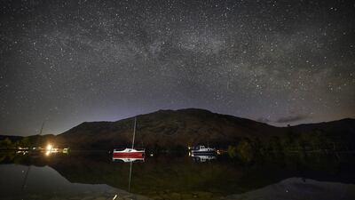 The Milky Way shines during its peak at 2.30am on Wednesday, above boats moored on Ullswater in the Lake District, Cumbria. PA