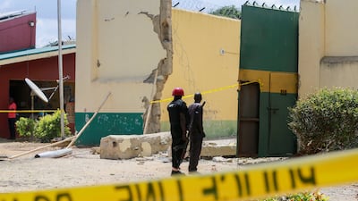 Prison officials stand near a gate destroyed with explosives by several gunmen during a prison break attack at the medium-security prison in Kuje, near the capital Abuja, Nigeria July 6, 2022. REUTERS / Afolabi Sotunde