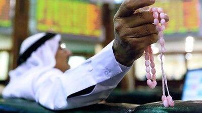 A man watches financial data on screens inside the Dubai Financial Market in Dubai.