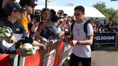 Mclaren driver Lando Norris signs autographs as he arrives at the track. AP