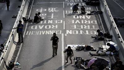Student activists sleep, sit and walk on a road near the government headquarters where pro-democracy activists have gathered and made camp in Hong Kong. Wong Maye-E / AP