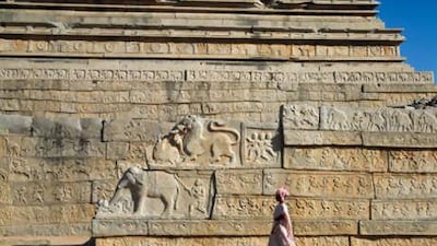 A woman walks past the Mahanavami platform in the royal enclosure at Hampi, which was used by Vijayanagara kings for viewing parades and public events.