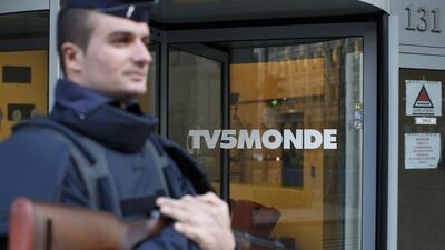 A French police officer stands guard in front of the main entrance of TV5Monde's headquarters in Paris on April 9, 2015. Benoit Tessier/Reuters