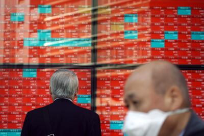A man looks at an electronic stock board showing Japan's Nikkei 225 index at a securities firm in Tokyo. AP