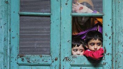 Kashmiri Muslims watch from a window as a sheep is sacrificed on the occasion of the religious festival of Eid al-Adha in Srinagar, India. Mukhtar Khan / AP