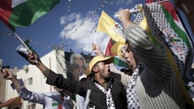 Palestinians shout slogans and wave their national flag as they attend a rally commemorating the fifth anniversary of late Palestinian leader Yasser Arafat's death in the West Bank city of in Ramallah on November 11, 2009.