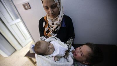 A Syrian refugee woman waits with her children for a check-up at a clinic managed by the French non-governmental organisation Medecins Sans Frontieres (MSF) in the Lebanese town of Arsal in the Bekaa Valley, the main crossing point for people fleeing Syria. MSF is assisting refugees through general medical consultations including treatment of acute and chronic diseases, immunisation, reproductive health care and mental health care, as well as distributing relief items. Joseph Eid / AFP Photo