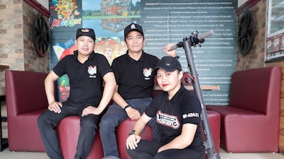 Restaurant workers Joylan Arcona, Perryl Malapitan and Sumaya Indog are members of a growing e-scooter community in Abu Dhabi. Victor Besa/The National