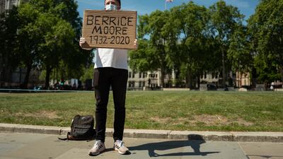 Ellis Tustin, grandson of Berrice Moore, holds up his grandfather's name as he stages a personal protest to Prime Minister Boris Johnson outside the Houses of Parliament on May 20. Getty Images