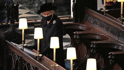 Queen Elizabeth watches pallbearers carry the coffin of her late husband, Prince Philip, the Duke of Edinburgh, into St George’s Chapel during the funeral at Windsor Castle in April.