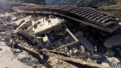 A building’s roof lies on top of a collapsed building in L’Aquila. Alberto Orsini / EPA