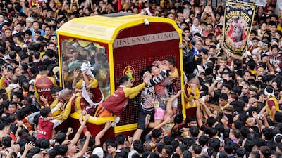 Catholic devotees try to touch the sculpture of Jesus being carried during a feast day procession in Manila, Philippines. EPA