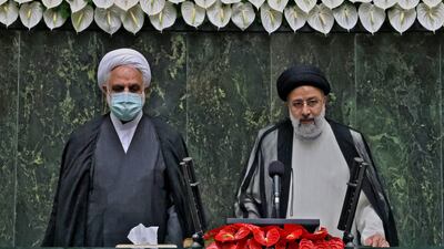 Iran's new President Ebrahim Raisi (right) takes the oath at the Iranian parliament in the capital Tehran