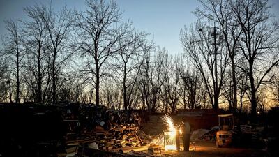 A Chinese labourer uses a welding torch to take apart scrap metal in the Dong Xiao Kou village. Kevin Frayer / Getty Images