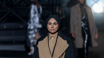 Zainab Al-Eqabi wears a trench coat with tie-belt at the Boss show at the Milan Fashion Week.