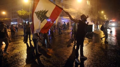 A Lebanese protester holds his national flag and shouts slogans during clashes following a demonstration, organised by the “You Stink” campaign, against the ongoing waste crisis in Beirut. AFP / STR