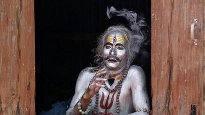 A devotee smokes as he waits to perform during the annual Hindu festival of Gajan on the outskirts of Agartala, India. Reuters