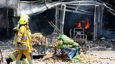 Firemen attend the blaze at the potato store in Al Aweer market in Dubai.