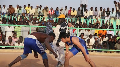 Nuba wrestler Kiri, left, faces off against Japan’s Kusuke Sunagawa, right, at a match in the Hajj Yousif wrestling arena in the Sudanese capital Khartoum on February 20, 2015. Sunagawa, 23, is helping to train a team of young Sudanese to compete in the Tokyo 2020 Olympics. Tom Little / AFP Photo
