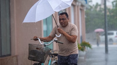 A man walks with an umbrella as heavy rain hits Sharjah. Ahmed Ramzan / The National