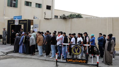 Egyptians wait outside a polling station in Cairo. The country's parliamentary elections have been mired in accusations of vote buying and ballot box tampering. AP