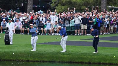 Tom Kim, Tiger Woods, and Rory McIlroy skim the ball across the pond on the 16th during a practice round. Reuters
