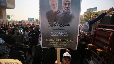 An Iraqi boy carries the portraits of Iraqi commander Abu Mahdi al-Muhandis and Iranian Revolutionary Guards commander Qasem Soleimani during a demonstration in Baghdad's western Shoala neighbourhood. AFP