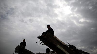 Displaced boys who had fled their homes wait outside Hammam al-Alil camp south of Mosul, Iraq. Muhammad Hamed / Reuters