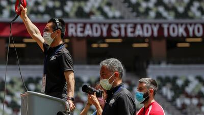 Officials are seen wearing masks during the morning session of the athletics test event. Reuters
