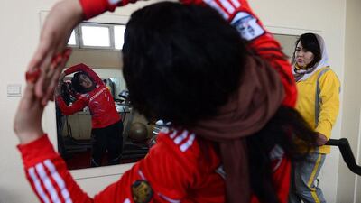 Twenty-one year old Afghanistan national powerlifting team member Sadya Ayubi looks on as she and others take part in a training session.