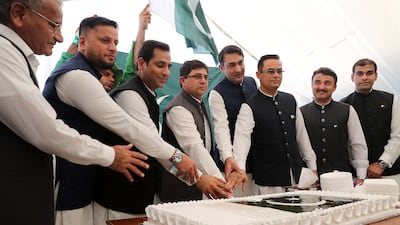 Mr Khan, centre, is joined by other officials to cut a cake as part of the Independence Day celebrations.