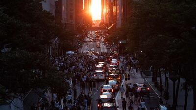 The sun sets over Manhattan on 42nd street during "Manhattanhenge" in New York, July 11, 2022. - The Manhattanhenge is an event in which the sunset or sunrise is aligned on the east-west grid of main streets in Manhattan, New York. (Photo by Yuki IWAMURA / AFP)