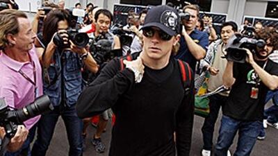Kimi Raikkonen moves past waiting media into his team building at the Suzuka Circuit ahead of Sunday's Japanese Grand Prix .