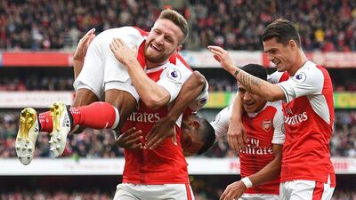 Arsenal’s English midfielder Theo Walcott, left, celebrates with Shkodran Mustafi, second from left, Alexis Sanchez, second from right, and Granit Xhaka after scoring their second goal against Swansea City at Emirates Stadium in London on October 15, 2016. Arsenal won the game 3-2. Justin Tallis / AFP