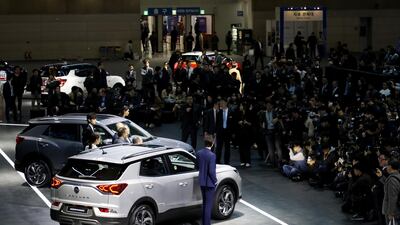 Members of the media take photographs of Ssangyong Korando sports utility vehicles. Seong Joon Cho / Bloomberg