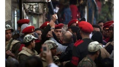 Military police officers scuffle with protesters as they try to clear Tahrir Square in Cairo yesterday.