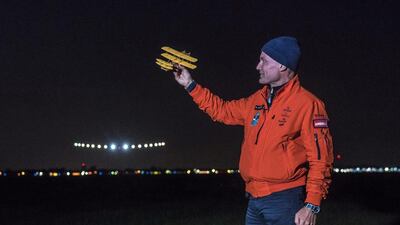 Swiss adventurer Bertrand Piccard holds a model of a plane designed by the Wright brothers as he welcomes the Solar Impulse 2, piloted by Andre Borschberg, to Dayton International Airport in Ohio on Saturday. Reuters