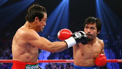 Manny Pacquiao, right, throws a right at Juan Manuel Marquez, left, during their welterweight bout at the MGM Grand Garden Arena. Al Bello / Getty Images