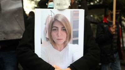 A person holds a picture of a woman who was killed during the Beirut port explosion at a sit-in to mark its six-month anniversary, in Beirut, Lebanon. Reuters